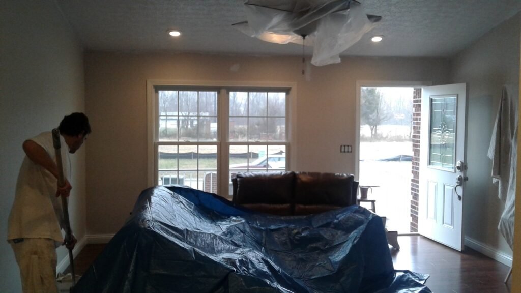 MCM painter working beside covered furniture